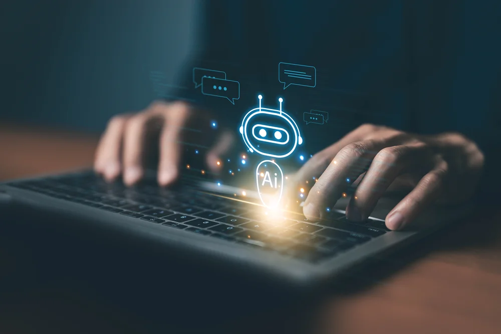 Person using AI on a laptop with a glowing AI assistant icon - WordPress 7.0 brings AI into the core.
